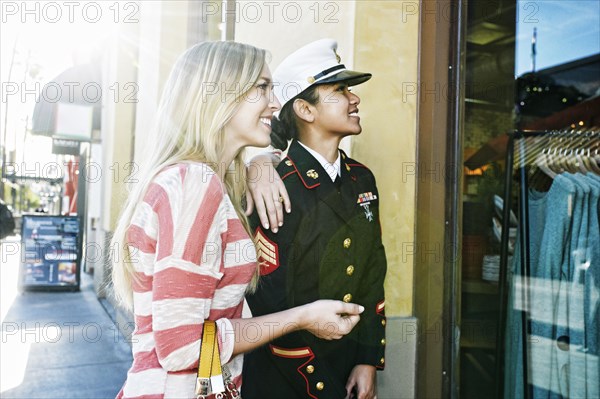 Asian soldier and friend window shopping