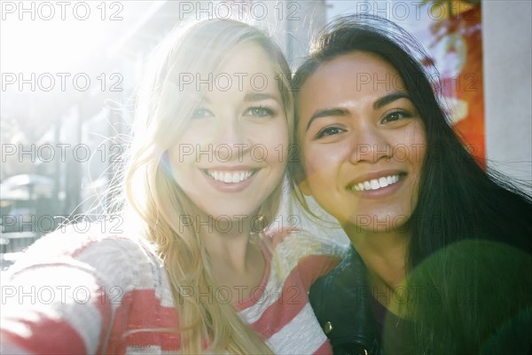 Close up of smiling women hugging outdoors