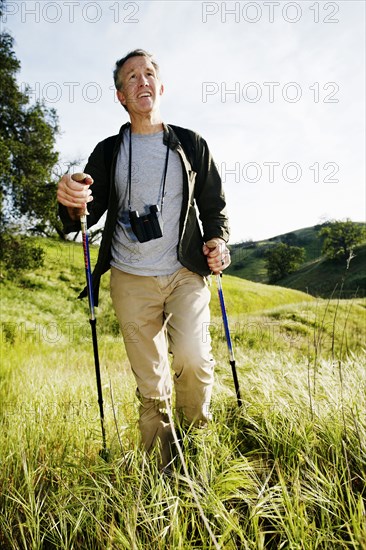 Caucasian man hiking in grass on mountain