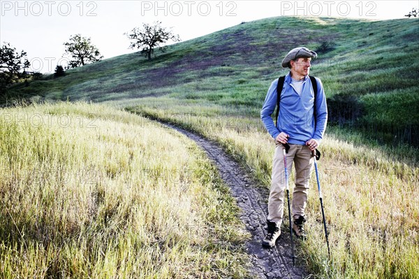 Caucasian man hiking on dirt path on mountain