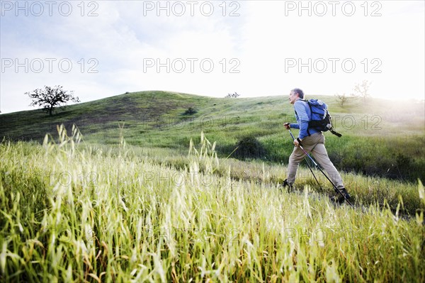 Caucasian man hiking in on mountain path