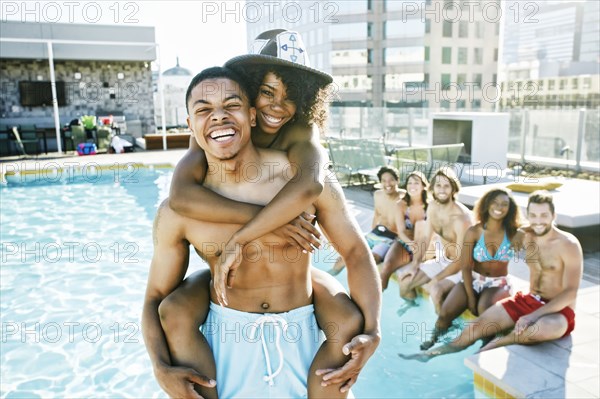 Smiling friends enjoying urban swimming pool