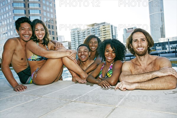 Smiling friends enjoying urban swimming pool