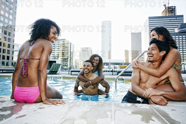 Smiling friends enjoying urban swimming pool