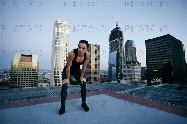 Caucasian woman resting on urban rooftop