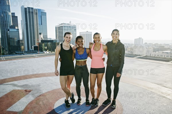 Smiling women posing on urban rooftop