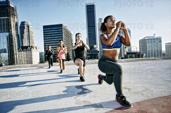 Woman stretching legs on urban rooftop