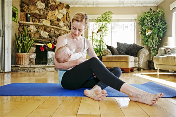 Mother resting from working out breastfeeding baby