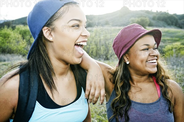 Mixed Race sisters laughing in field