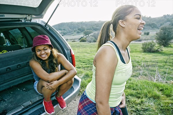 Mixed Race at hatch of car laughing