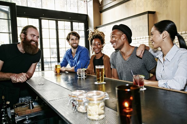 Smiling bartender and customers at bar