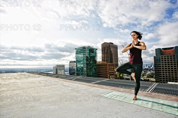 Caucasian woman doing yoga urban rooftop