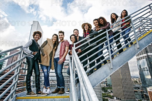 Stylish friends posing on urban metal staircase
