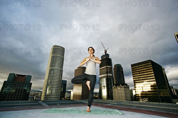 Caucasian woman doing yoga urban rooftop