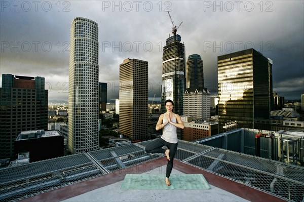 Caucasian woman doing yoga urban rooftop