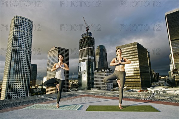 Caucasian women doing yoga urban rooftop