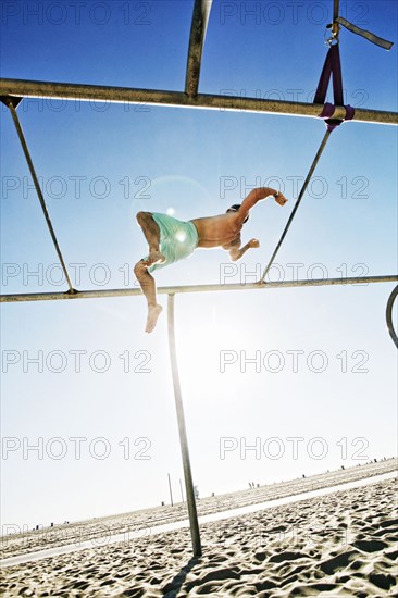 Caucasian man flipping on beach