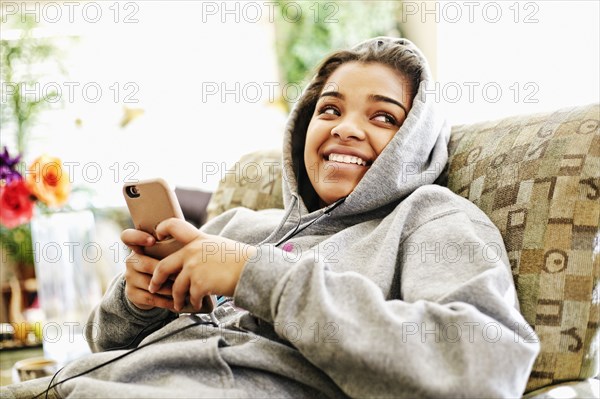 Mixed Race woman sitting on chair listening to cell phone