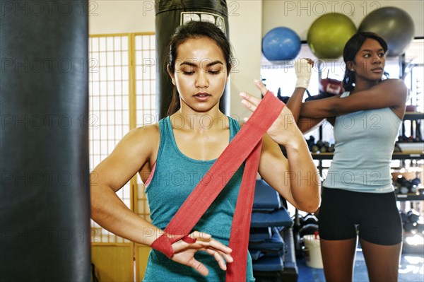 Woman wrapping hand in gymnasium