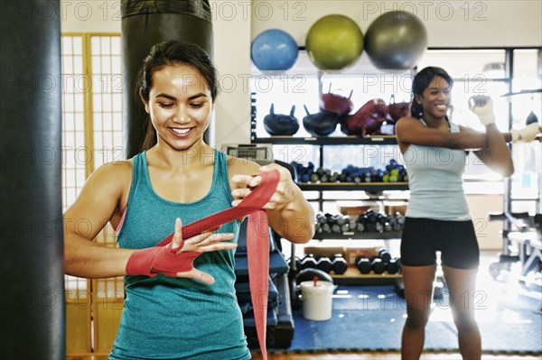 Woman wrapping hand in gymnasium