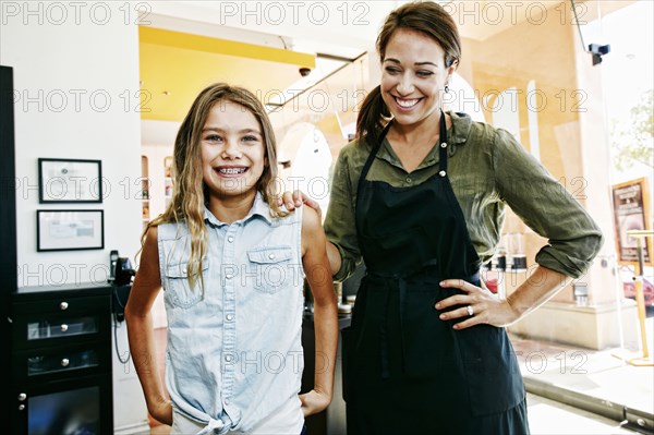 Smiling hairdresser and customer posing in hair salon