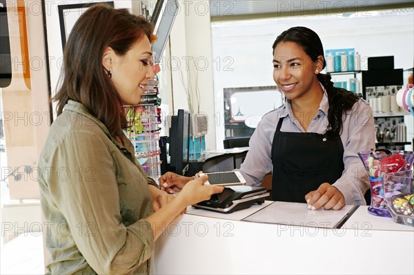 Customer paying in hair salon with cell phone