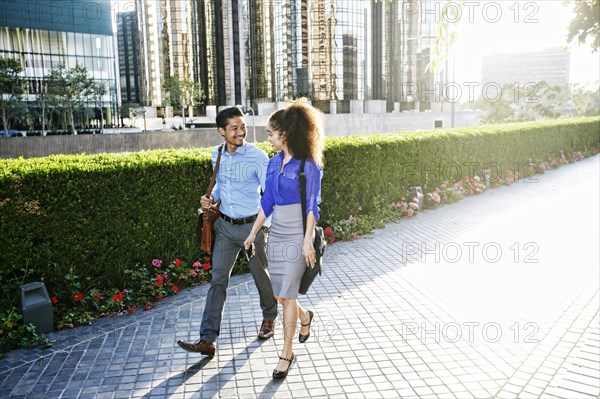 Smiling business people talking and walking outdoors