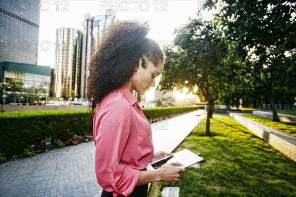 Hispanic businesswoman using digital tablet outdoors