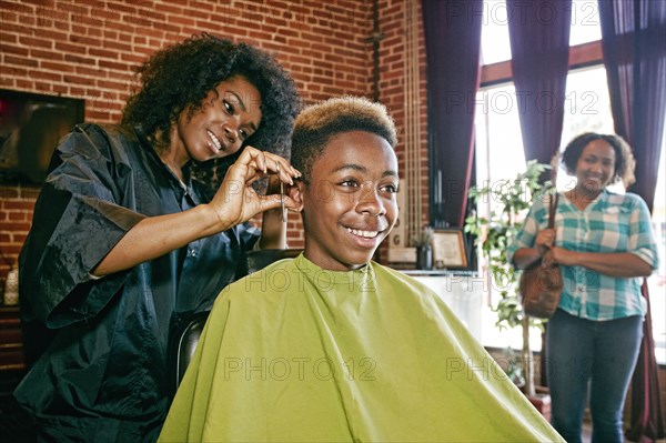 Smiling hairdresser and customers in hair salon