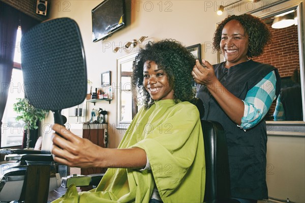 Smiling hairdresser and customer in hair salon