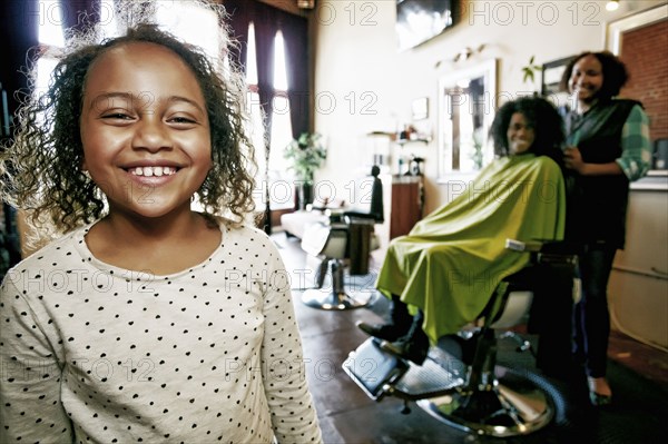 Smiling hairdresser and customers in hair salon