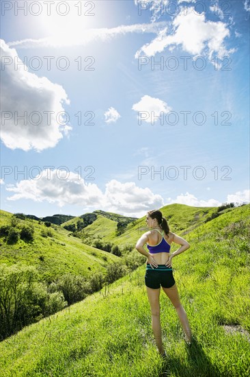 Pensive Caucasian woman standing on hill