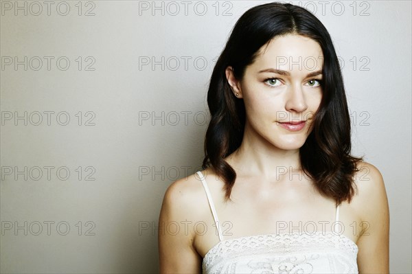 Serious Caucasian woman posing near wall