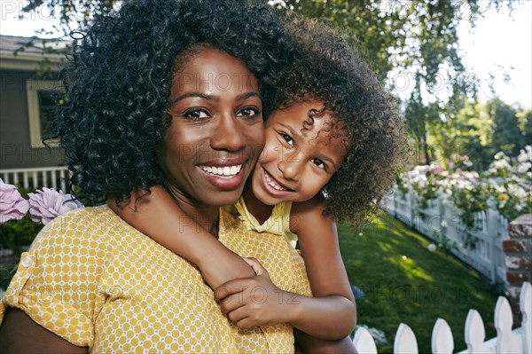 Daughter hugging mother outdoors