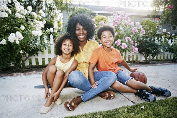 Smiling family sitting on skateboard