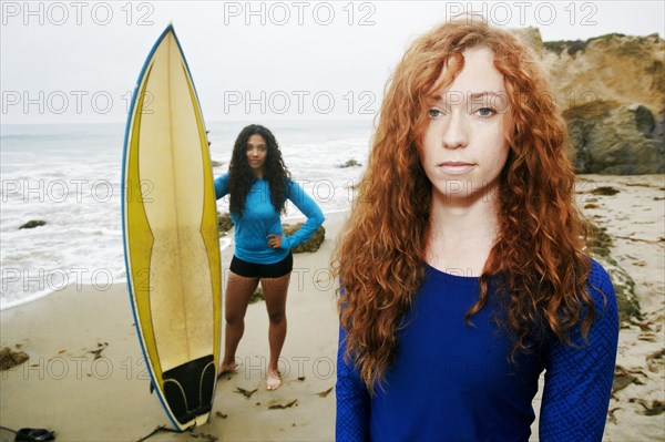 Serious women holding surfboards at beach