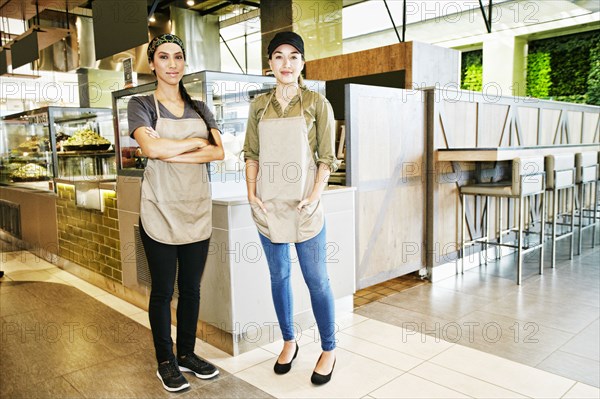 Portrait of smiling workers in food court