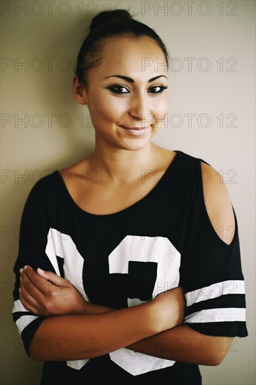 Portrait of smiling Mixed Race woman leaning on wall