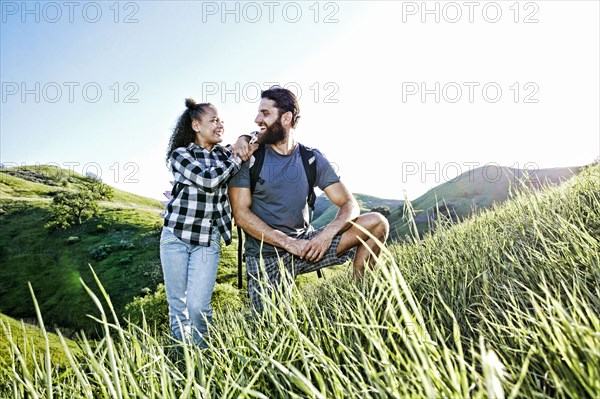 Father and daughter smiling on hill