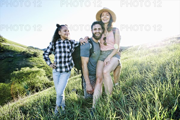 Portrait of smiling family posing on hill