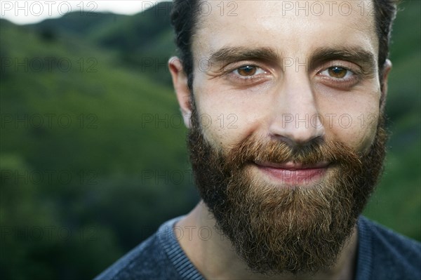 Close up of smiling Mixed Race man with beard