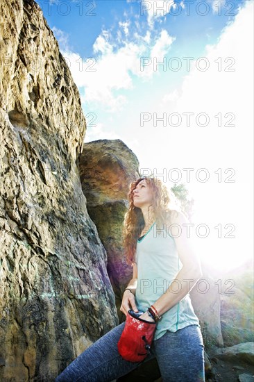 Caucasian woman chalking hands for rock climbing