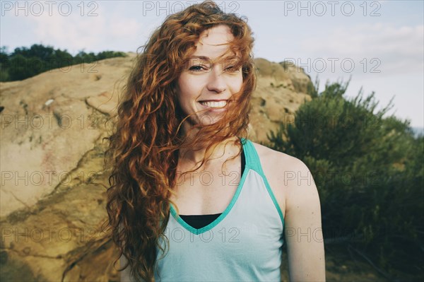 Caucasian woman standing near boulder in wind