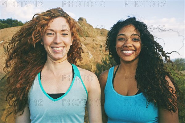 Women standing near boulder in wind