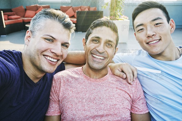 Smiling men posing on rooftop