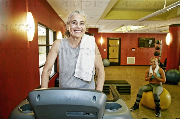 Smiling Caucasian mother and daughter in gymnasium