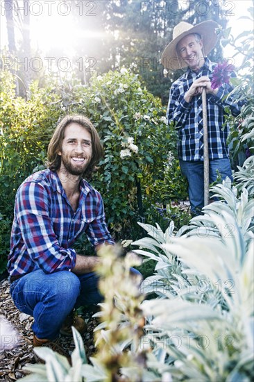 Smiling Caucasian men posing in garden