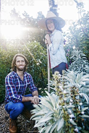 Smiling Caucasian couple posing in garden