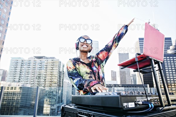 Smiling Black DJ on urban rooftop