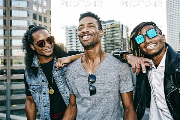 Portrait of men smiling on urban rooftop